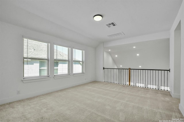 empty room with light carpet and vaulted ceiling