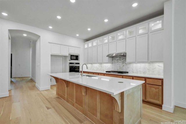 kitchen with sink, white cabinetry, an island with sink, and stainless steel appliances