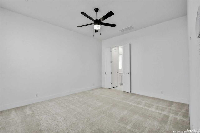 empty room featuring ceiling fan and light colored carpet