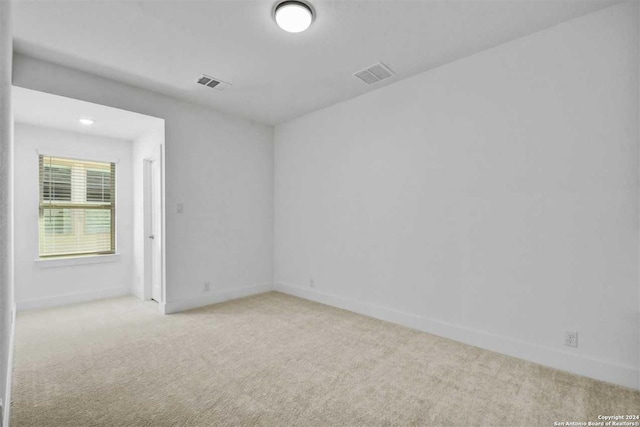 unfurnished room featuring light colored carpet