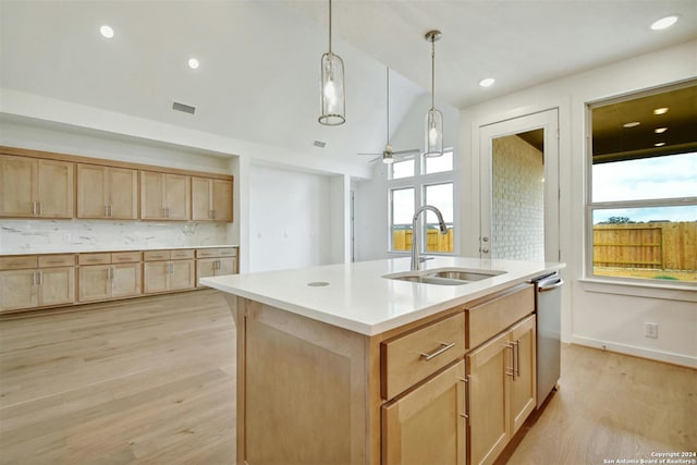 kitchen featuring ceiling fan, sink, an island with sink, decorative light fixtures, and light wood-type flooring