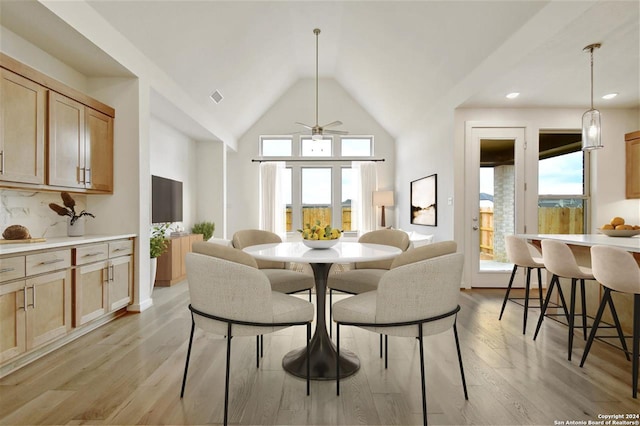 dining area with ceiling fan, high vaulted ceiling, and light hardwood / wood-style floors