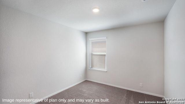 unfurnished room featuring dark colored carpet