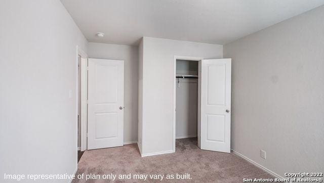 unfurnished bedroom with a closet and light carpet