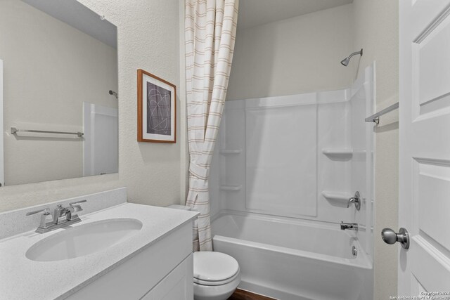 full bathroom featuring toilet, shower / bath combo with shower curtain, and vanity