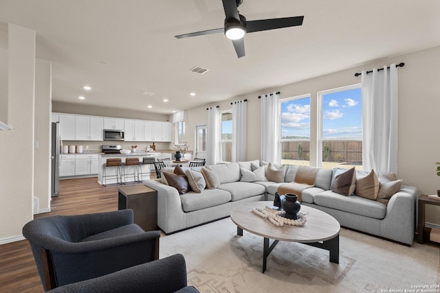 living room with light hardwood / wood-style floors and ceiling fan