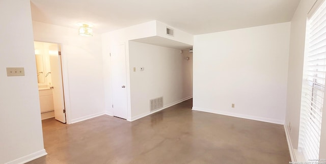 empty room with visible vents, baseboards, and finished concrete floors