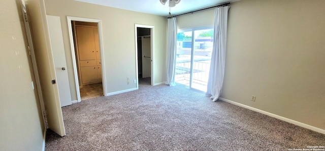 unfurnished bedroom featuring a spacious closet, a closet, and carpet