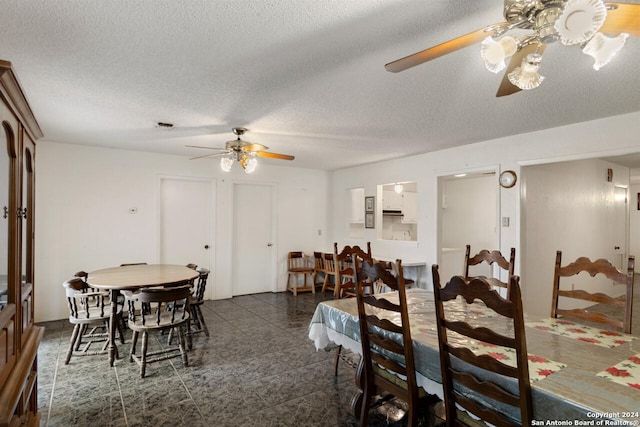 dining space featuring a textured ceiling and ceiling fan