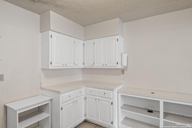 laundry area with light tile patterned floors and a textured ceiling