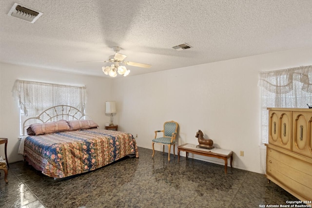 bedroom featuring ceiling fan and a textured ceiling