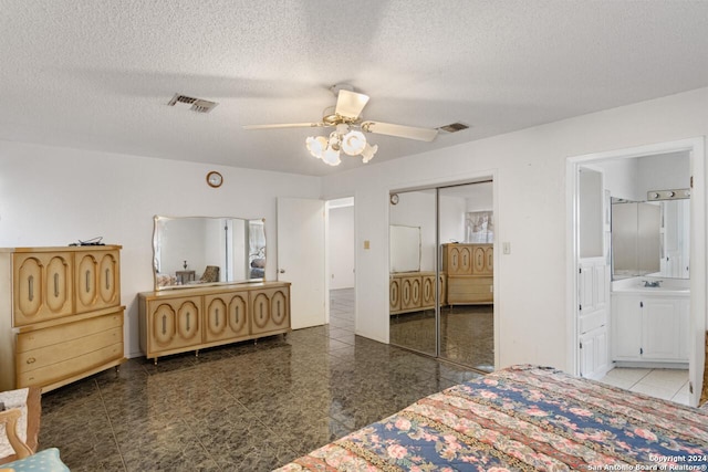 bedroom with ceiling fan, a closet, ensuite bathroom, and a textured ceiling