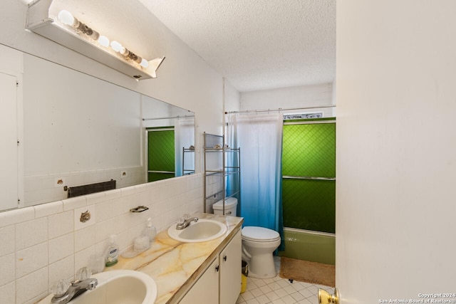 full bathroom with vanity, toilet, shower / bathtub combination with curtain, a textured ceiling, and tile walls