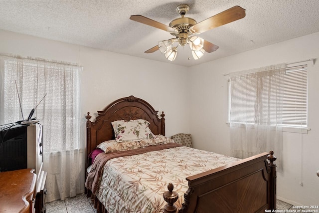 tiled bedroom featuring a textured ceiling and ceiling fan