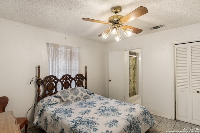 bedroom with ceiling fan, a closet, light tile patterned floors, and a textured ceiling