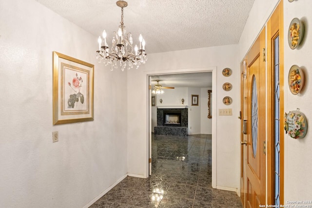 hallway featuring a notable chandelier and a textured ceiling