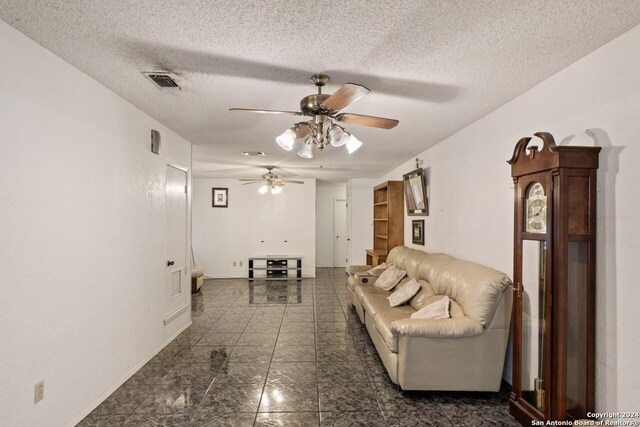 living room with ceiling fan and a textured ceiling