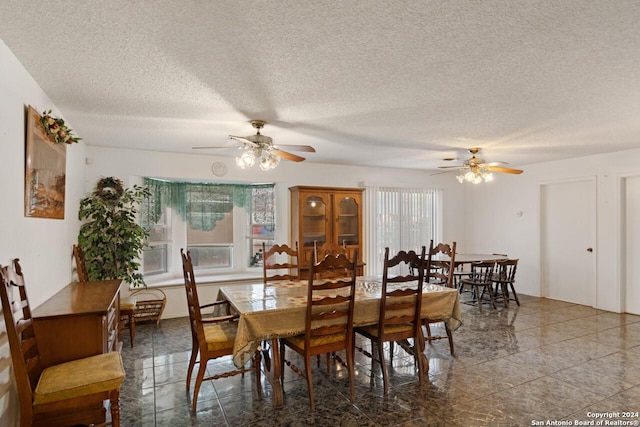 dining area with ceiling fan and a textured ceiling