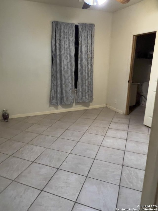 unfurnished room with ceiling fan and light tile patterned floors