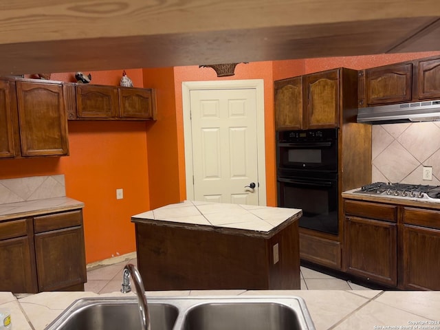 kitchen with tasteful backsplash, black double oven, sink, range hood, and light tile patterned flooring