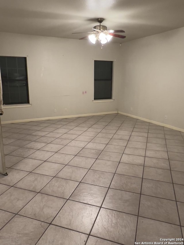 tiled empty room featuring ceiling fan