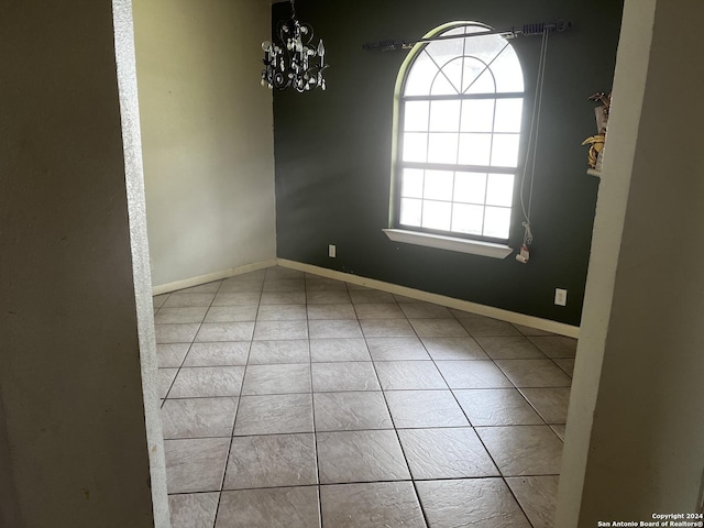 spare room with a wealth of natural light and a chandelier