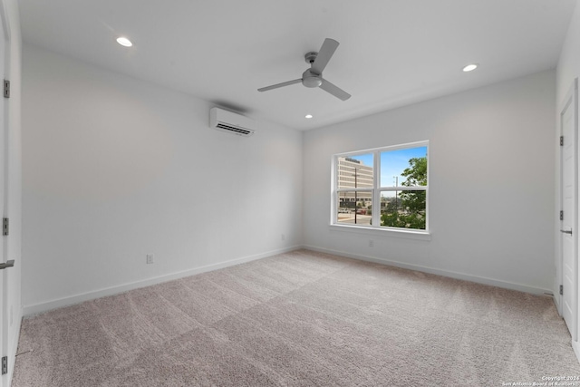 spare room featuring light carpet, a wall mounted air conditioner, and ceiling fan