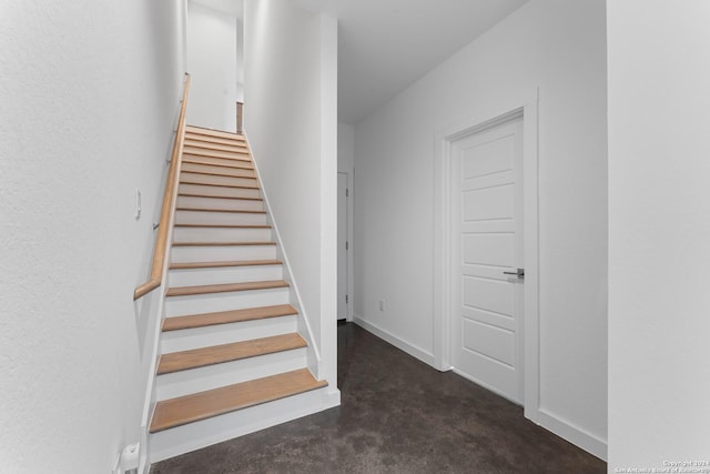 staircase featuring concrete floors