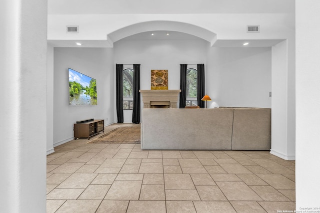 interior space with a towering ceiling and light tile patterned flooring