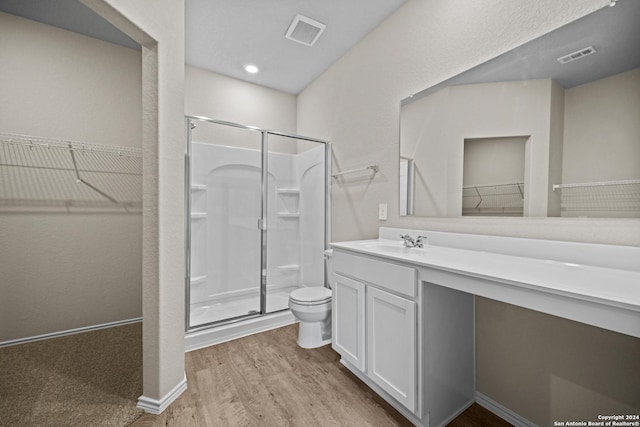 bathroom with vanity, toilet, wood-type flooring, and walk in shower