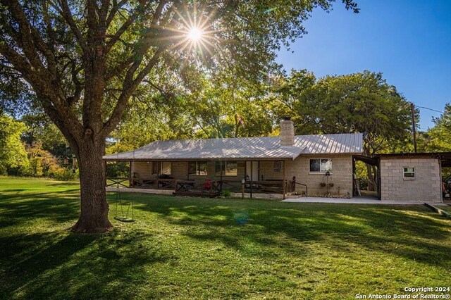 rear view of house featuring an outdoor structure and a yard