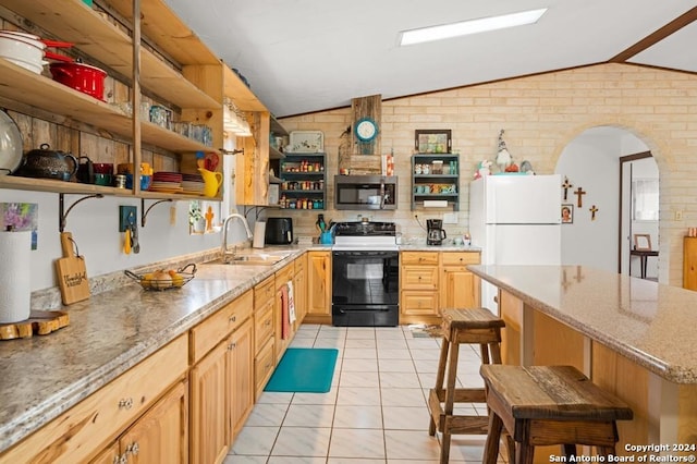 kitchen with a kitchen breakfast bar, brick wall, white appliances, sink, and lofted ceiling