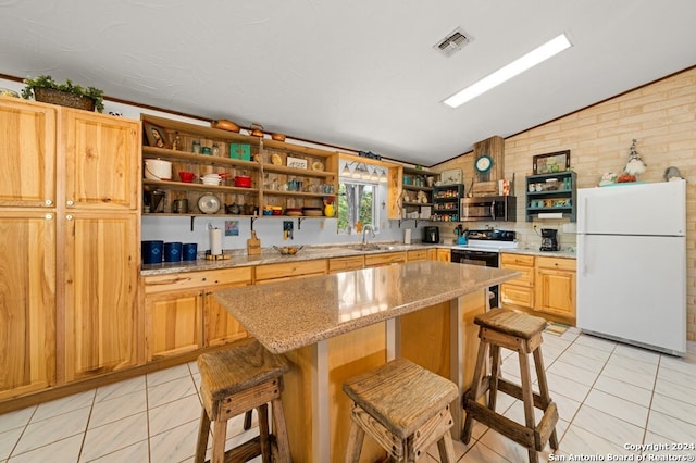 kitchen with a center island, a kitchen bar, white appliances, and sink