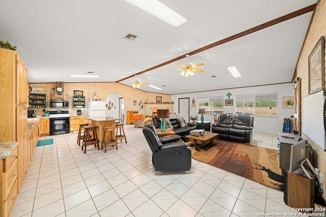 tiled living room featuring ceiling fan and lofted ceiling