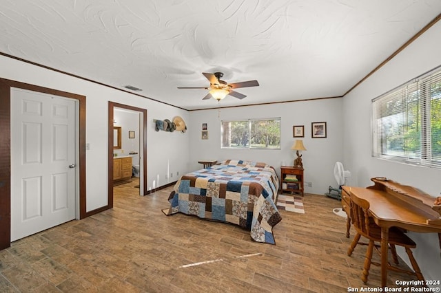 bedroom with hardwood / wood-style flooring, ceiling fan, ornamental molding, and ensuite bathroom