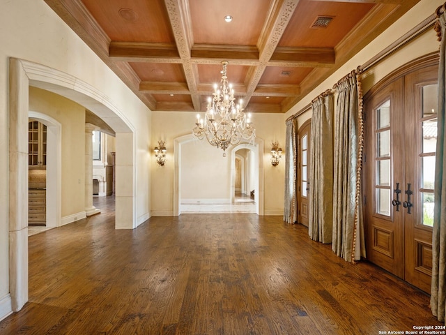 interior space featuring coffered ceiling, beamed ceiling, dark hardwood / wood-style floors, a notable chandelier, and ornamental molding