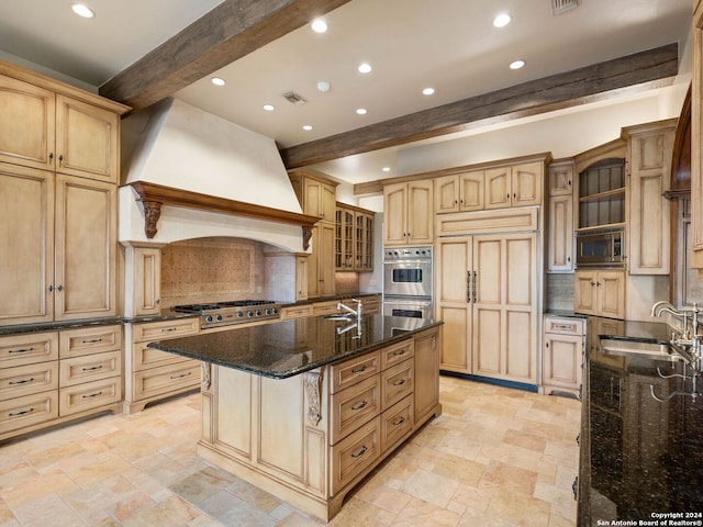 kitchen with custom exhaust hood, sink, beam ceiling, built in appliances, and a center island with sink