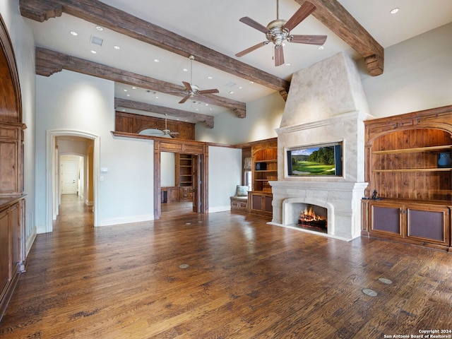 unfurnished living room featuring ceiling fan, wood-type flooring, and a towering ceiling