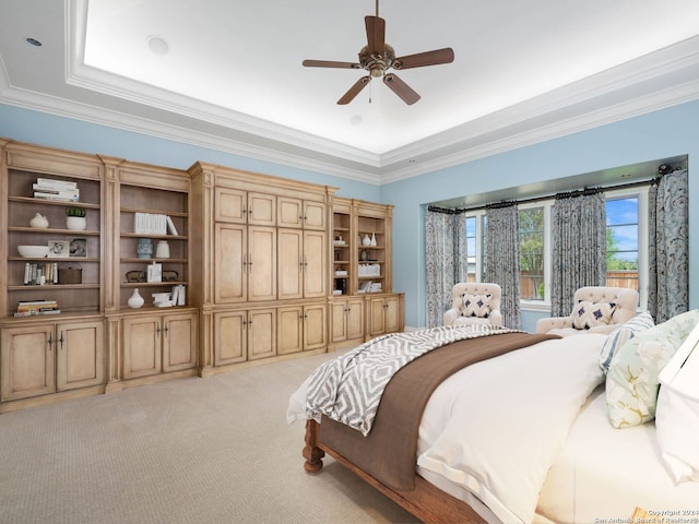 carpeted bedroom with a raised ceiling, ceiling fan, and ornamental molding