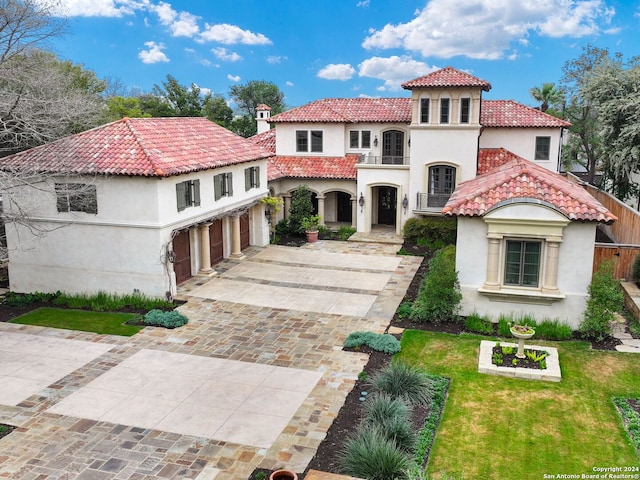 mediterranean / spanish-style home featuring a balcony, a garage, and a front lawn