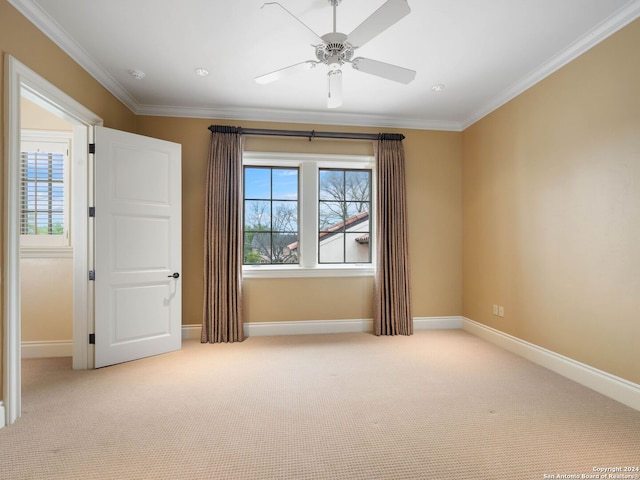 unfurnished room with light carpet, ceiling fan, and crown molding