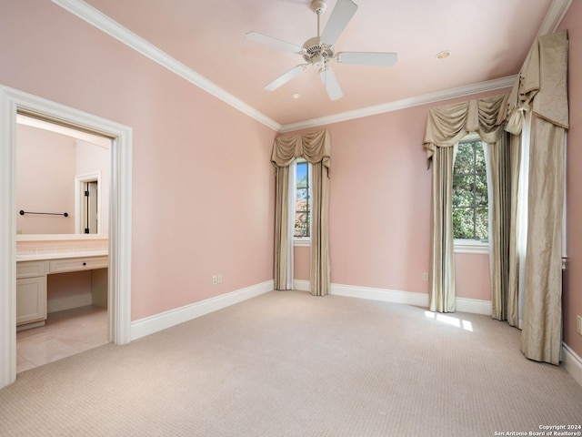 unfurnished bedroom featuring ensuite bathroom, ceiling fan, light carpet, and multiple windows