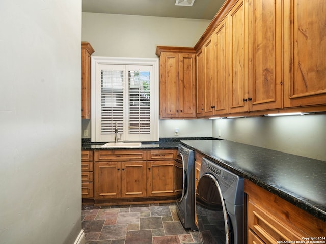 laundry area with cabinets, washing machine and dryer, and sink