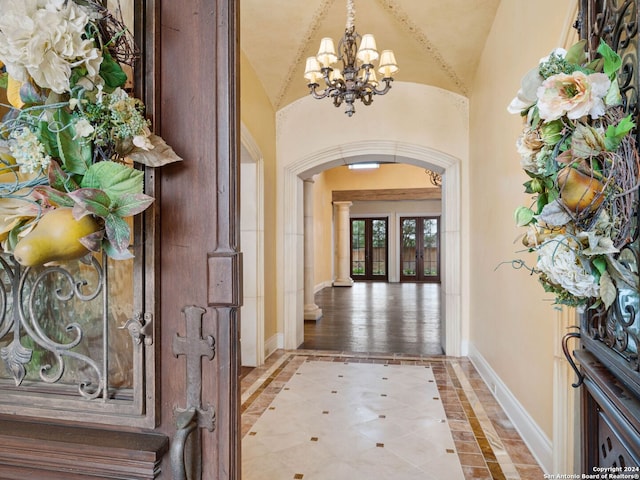 entryway featuring a chandelier, light hardwood / wood-style floors, and lofted ceiling