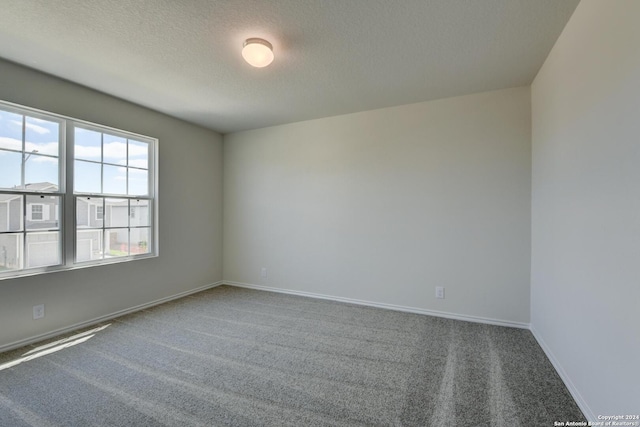 carpeted spare room with a textured ceiling