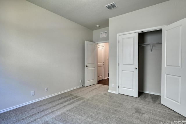 unfurnished bedroom with light carpet and a closet