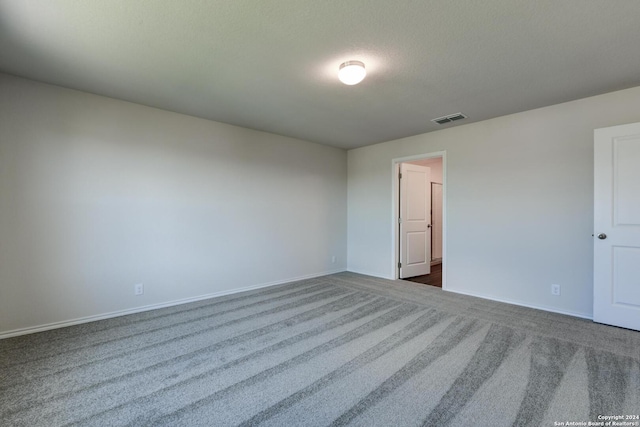 carpeted spare room featuring a textured ceiling