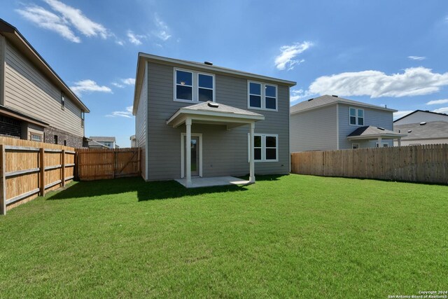 rear view of property featuring a yard and a patio area