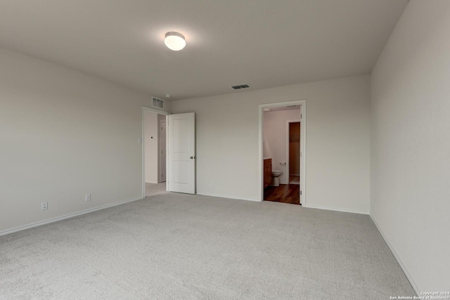 unfurnished bedroom with carpet flooring and connected bathroom