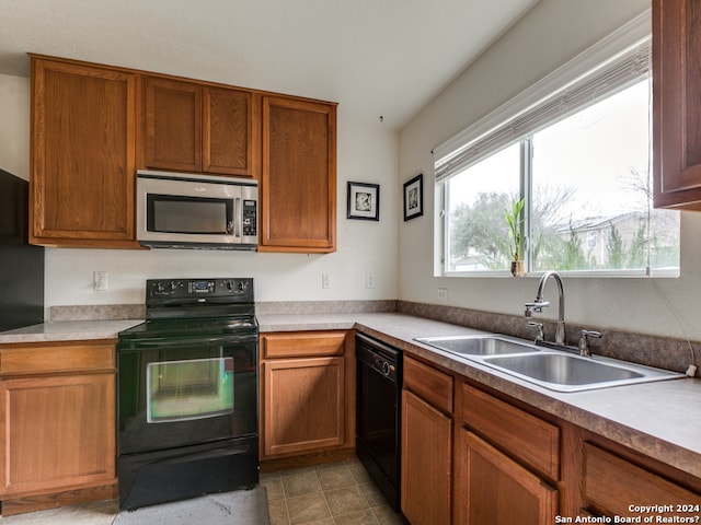 kitchen with light tile patterned floors, sink, and black appliances